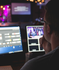 Man handling video equipment at worship service - MinistryTech.com